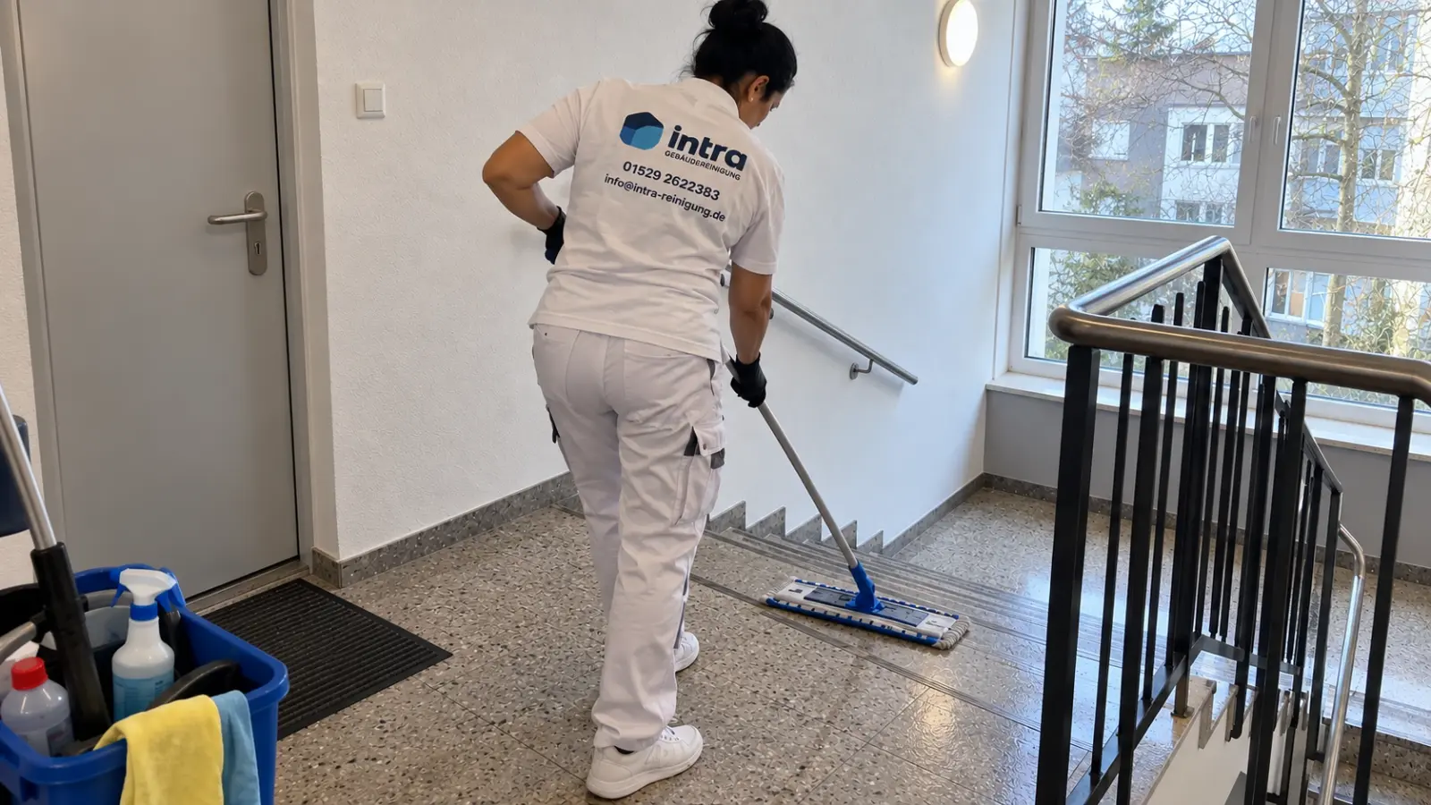 Mitarbeiterin saugt die Treppenstufen bei der Treppenhausreinigung in Soest
