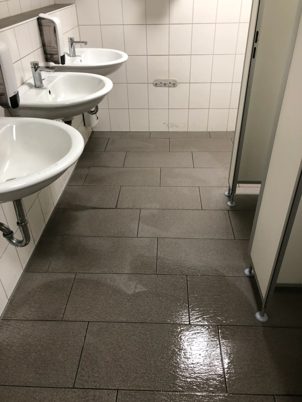 Frisch gewischter Fliesenboden in einer Sanitäranlage in Soest